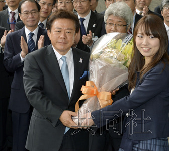 12月18日，高票當(dāng)選東京都新知事的豬瀨直樹(shù)正式到任。圖為豬瀨從政府職員手中接過(guò)花束。(共同社)