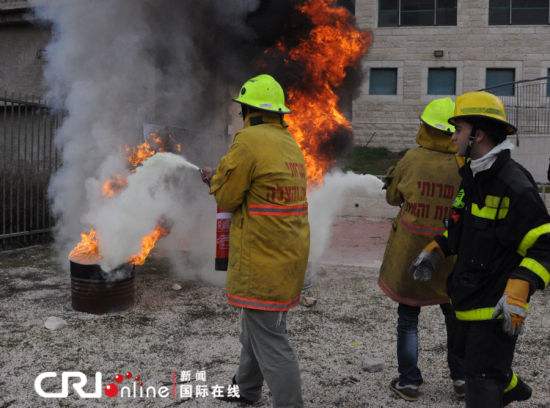 兩名志愿者在消防員的指揮下滅火。（攝影：張瑾） 