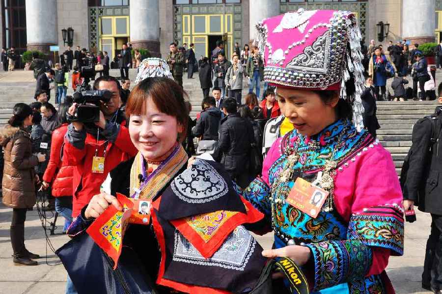 云南代表團(tuán)的兩位女代表在為記者展示她們帶來的民族特色手工藝品。 人民網(wǎng)記者 馬麗婭 攝