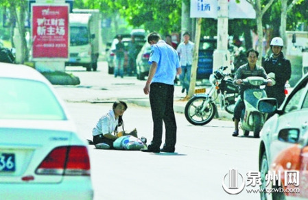 女孩從摩的上摔下，跌坐路中央，恰遇社區(qū)聯(lián)防巡邏人員扶起。