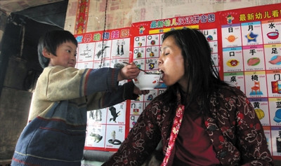 小孫悅為臥床的母親喂飯。