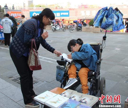 洛洛正在給買書的顧客簽名。 馮曉林 攝